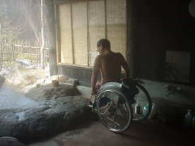 おっとんが車いすから浴槽に入ろうとしています。