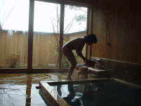 おかんがお湯の湯加減を見ている。