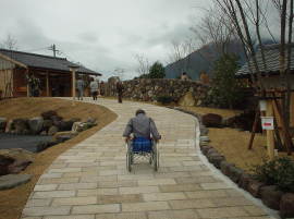 家族湯に向かって急坂を車いすで上っているおっとん。
