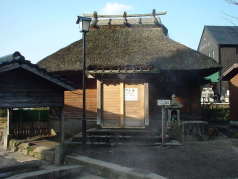 昔風のワラ葺き屋根の下ん湯入り口